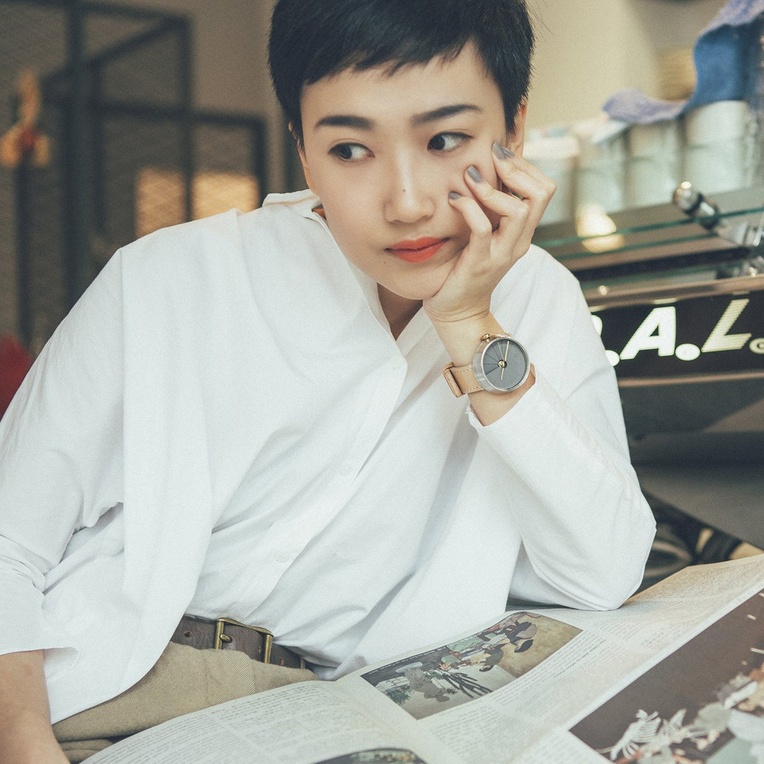 Woman With A White Shirt In A Cafe Wearing A Modern Watch With A Nude Colored Strap