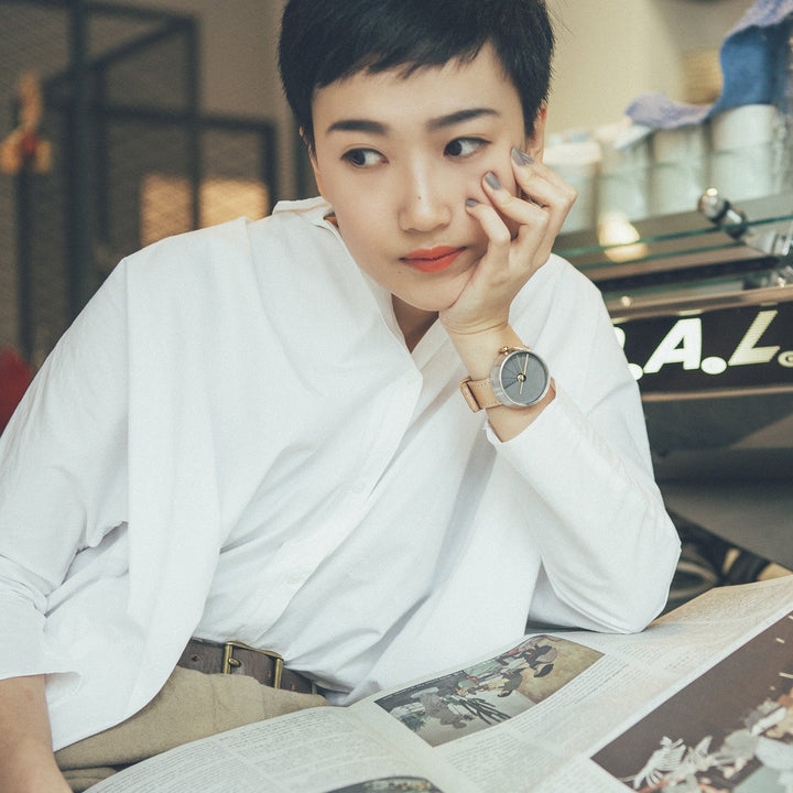 Woman With A White Shirt In A Cafe Wearing A Modern Watch With A Nude Colored Strap