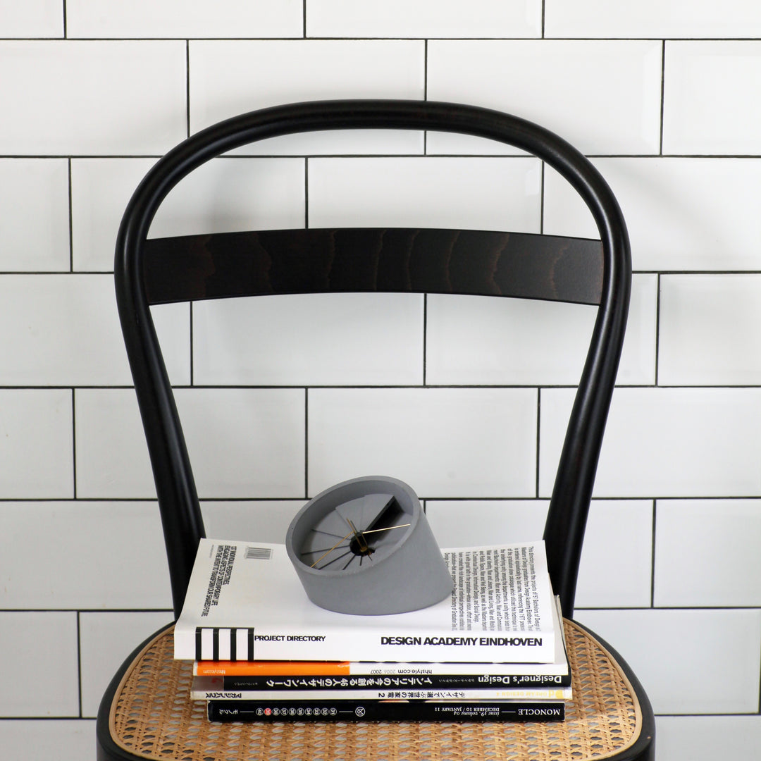 Table Clock on top of a chair and magazines