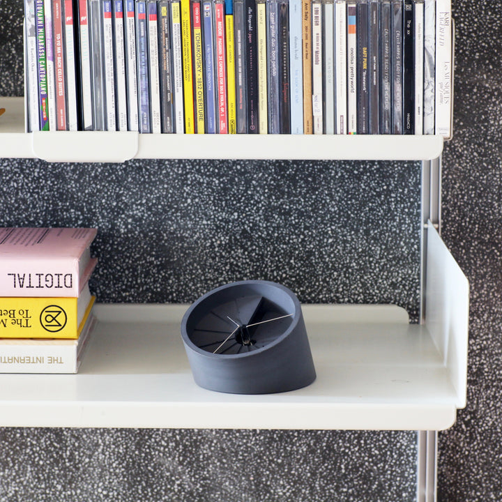 Table clock on bookshelf with CDs