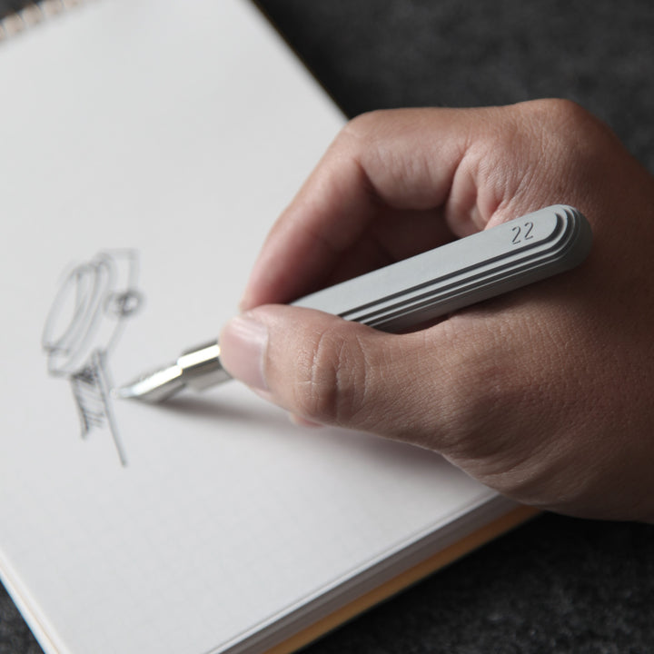 A Man Drawing a Watch with a 22STUDIO Concrete Fountain Pen