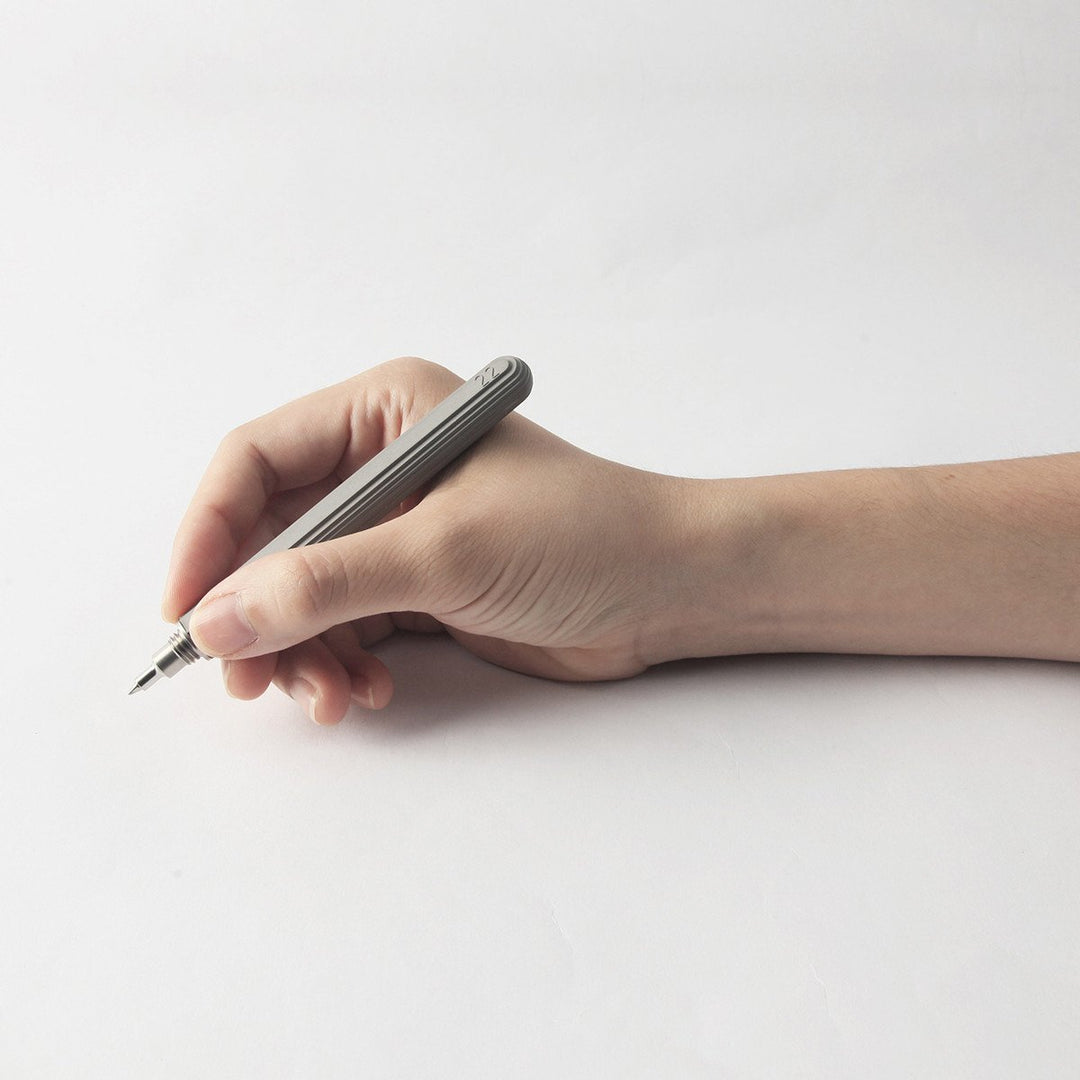 A Hand Holding a Light Gray Cement Pen 