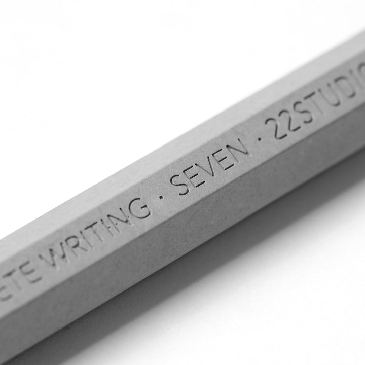 Close-Up View Of The Word Seven Engraved Into A 22STUDIO Concrete Pen